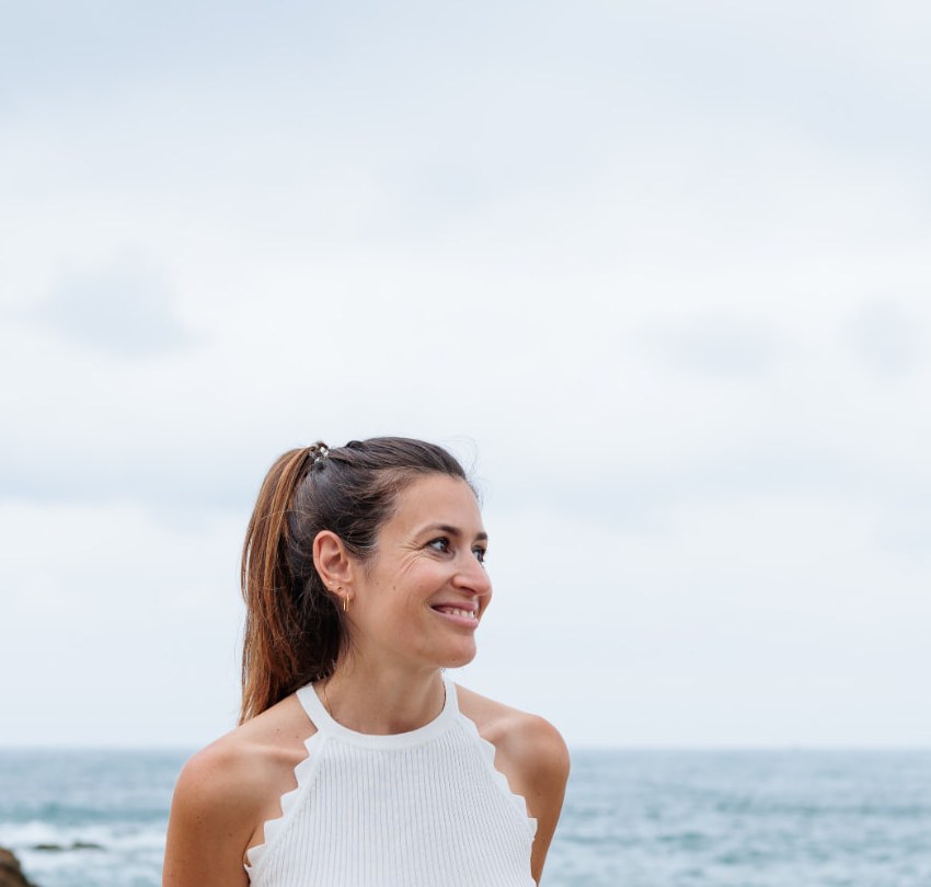 Fanny Gand, sophrologue et professeure de yoga, souriante devant l'océan à Biarritz